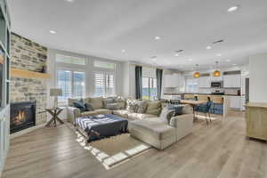 Living room with a fireplace and light wood-type flooring