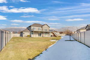 Back of property featuring a mountain view and a lawn