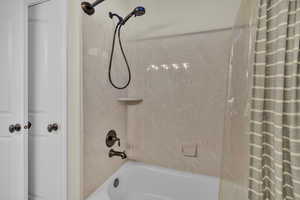 Bathroom with shower / bath combination with curtain