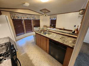 Kitchen featuring black dishwasher, gas range, vaulted ceiling, white refrigerator, and sink