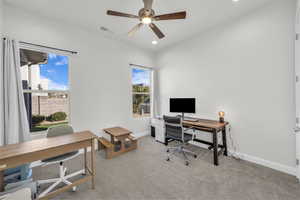 Office space with light carpet and ceiling fan