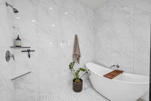 Bathroom featuring tile walls and plus walk in shower