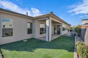 Rear view of house with a yard and a patio