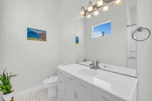 Bathroom featuring toilet, vanity, and tile patterned flooring