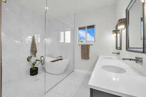 Bathroom featuring vanity, tile walls, and a tub