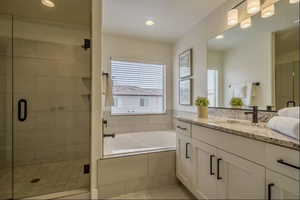 Bathroom with shower with separate bathtub, tile patterned floors, and vanity