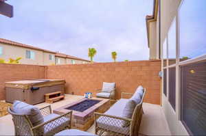 View of patio / terrace with a hot tub and a fire pit