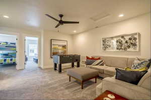 Carpeted living room with ceiling fan