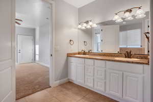 Bathroom with ceiling fan, a wealth of natural light, vanity, and tile patterned flooring