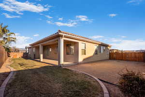 Back of house featuring a lawn and a patio