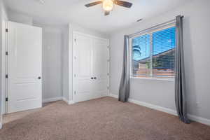 Unfurnished bedroom featuring light carpet, a closet, and ceiling fan