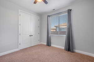 Unfurnished bedroom featuring ceiling fan, carpet flooring, and a closet