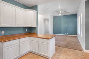 Kitchen featuring white cabinets, kitchen peninsula, and light tile patterned flooring