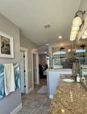 Bathroom featuring a shower with shower door and vanity