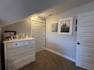 Unfurnished bedroom with dark colored carpet