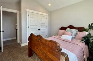 Bedroom with carpet floors, a closet, and lofted ceiling