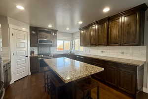 Kitchen with stainless steel appliances, dark brown cabinetry, and a kitchen island