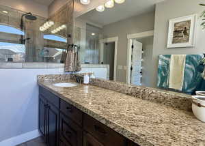 Bathroom featuring vanity, tile patterned floors, and tiled shower