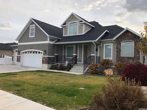 Craftsman inspired home featuring a front yard and covered porch