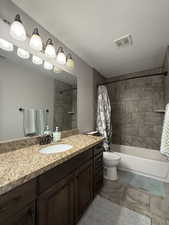 Full bathroom featuring toilet, vanity, and shower / bath combo with shower curtain