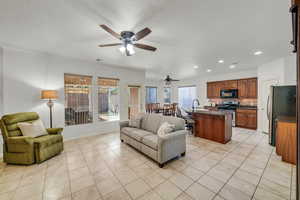 Living room featuring ceiling fan and light tile patterned floors