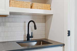 Kitchen with sink, white cabinets, and tasteful backsplash