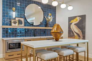 Dining room featuring tile walls, light hardwood / wood-style flooring, and sink