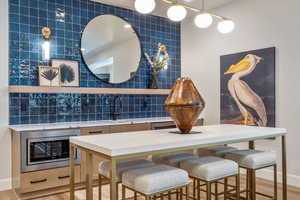 Dining area with sink, tile walls, and light wood-type flooring