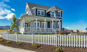 Victorian home with a front lawn and a porch