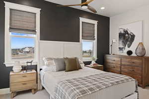 Carpeted bedroom featuring ceiling fan