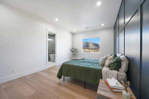 Bedroom with ensuite bathroom and light wood-type flooring