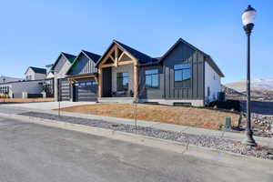 View of front of home featuring cooling unit, a garage, and a mountain view