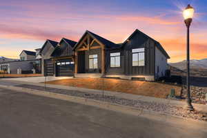 View of front of house with central AC unit, a mountain view, and a garage