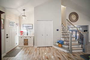 Entryway with lofted ceiling and light wood-type flooring