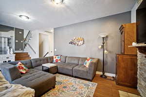 Living room featuring a textured ceiling and light hardwood / wood-style flooring