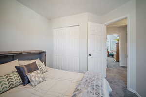 Carpeted bedroom with a closet