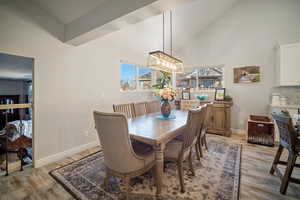 Dining room featuring high vaulted ceiling and light wood-type flooring