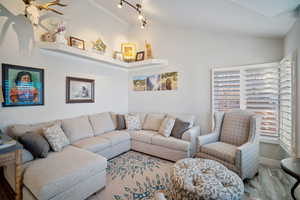 Living room with vaulted ceiling and hardwood / wood-style floors