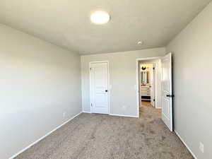 Unfurnished bedroom with a textured ceiling and carpet