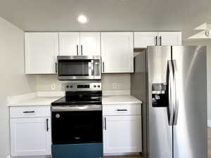 Kitchen featuring stainless steel appliances and white cabinets