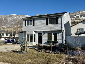 Rear view of property featuring a mountain view, a yard, and a patio