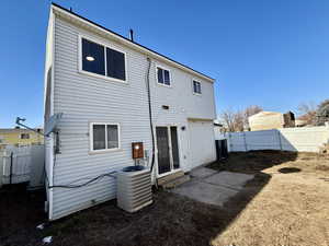 Rear view of property with central AC