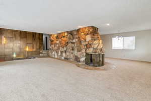 Living room with a fireplace, a textured ceiling, and carpet flooring