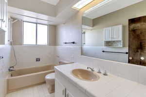 Full bathroom featuring toilet, vanity, tile patterned floors, and shower / bath combination