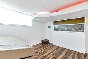 Office space with dark hardwood / wood-style floors and a textured ceiling