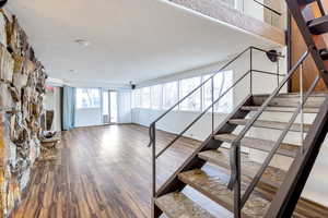 Stairs featuring a textured ceiling and hardwood / wood-style flooring