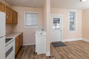 Kitchen and dining room with tasteful backsplash, sink, hardwood / wood-style floors, and white appliances