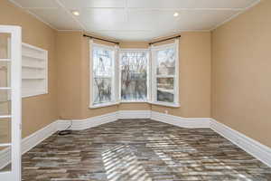 Empty room with built in shelves and dark wood-type flooring