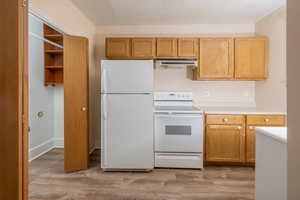 Kitchen featuring light wood-type flooring and white appliances