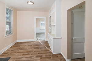 Hallway featuring hardwood / wood-style flooring and built in shelves